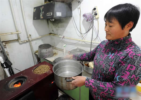 山东省阳信县劳店镇小杜村村民王冬梅用生物质清洁燃料热水做饭.jpg